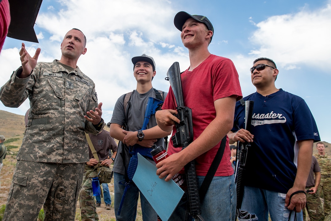 (Leah Hogsten  |  The Salt Lake Tribune) Porter Brown, 17, of Richfield and other attendees laugh with CW2 Jordan Watt with the 1st Battalion of the 211th Aviation Regiment as he gives details about his training and what it's like to fly an Apache helicopter at the Utah National Guard Special Forces Survival Training Experience, August 10-12 at Camp Williams.