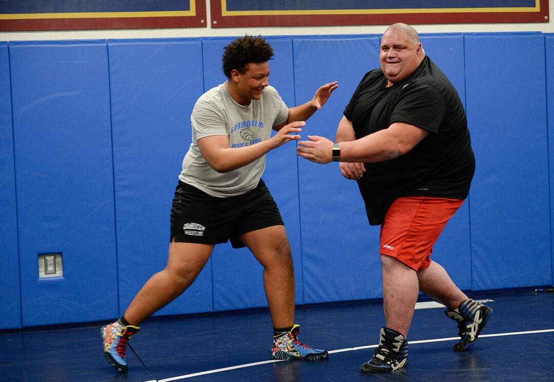 (Francisco Kjolseth  |  The Salt Lake Tribune)  Traycee Norman, 16, jokes around with Olympic wrestling champion Rulon Gardner during a recent clinic after being introduced as the new coach at Herriman High School. 