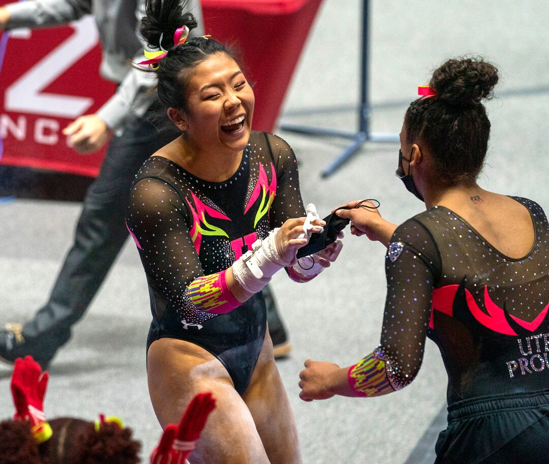 (Rick Egan | The Salt Lake Tribune) Cristal Isa grabs her mask from a teammate after her routine on the uneven bars, in PAC-12 gymnastics action Utah vs Arizona, at the Huntsman Center onSaturday, Jan. 23, 2021.