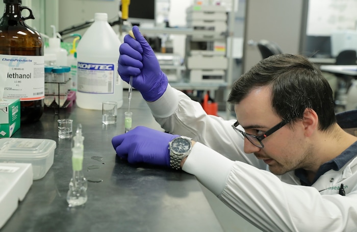 (Ted Warren | AP file photo) Pierce Prozy prepares a CBD vape oil test sample at Flora Research Laboratories in Grants Pass, Ore., on July 19, 2019. The Associated Press commissioned the lab to test 30 vape products marketed as delivering the cannabis extract CBD. The testing was part of an investigation that shows some people are taking advantage of gaps in federal regulation and law enforcement to exploit booming demand for CBD by substituting cheap and illegal synthetic marijuana for natural CBD.