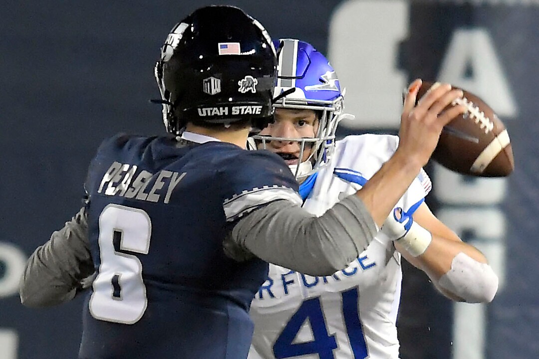 Utah State quarterback Andrew Peasley (6) looks to throw the ball as Air Force linebacker Matthew Malloy (41) defends during the first half of an NCAA college football game Thursday, Dec. 3, 2020, in Logan, Utah. (Eli Lucero/The Herald Journal via AP, Pool)