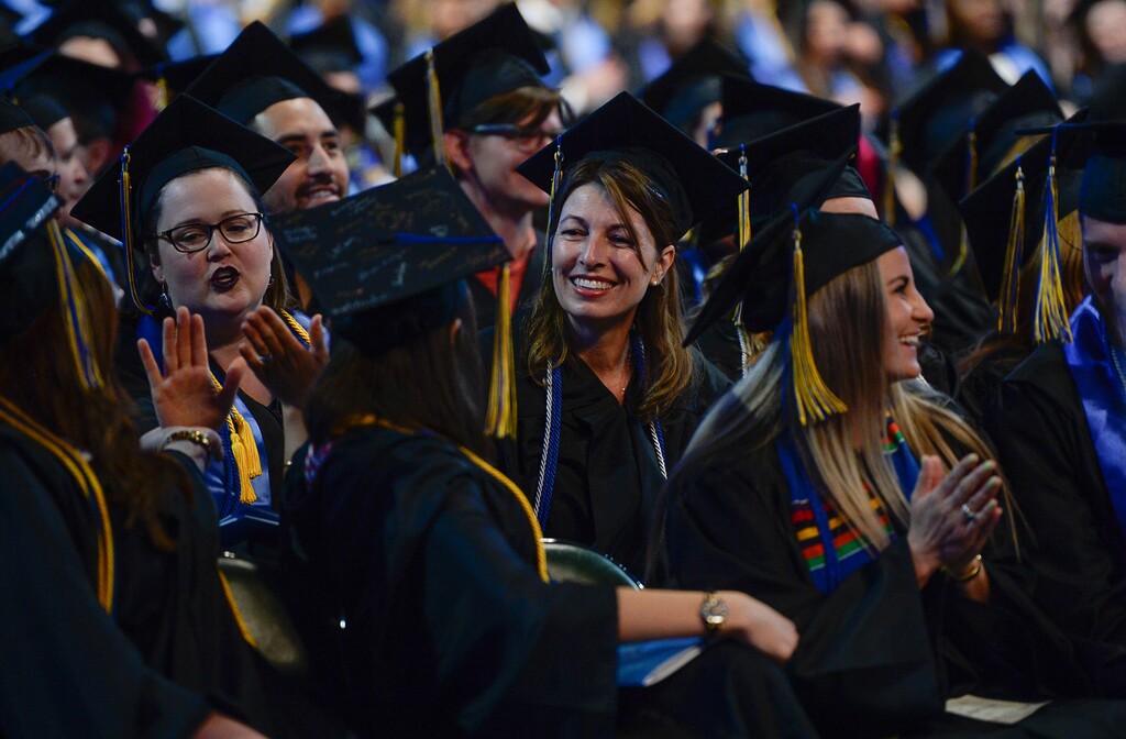 Francisco Kjolseth | The Salt Lake TribuneSalt Lake Community College graduates take a moment to congratulate their neighbors as directed by a speaker during commencement ceremonies at the Maverik Center on Friday, May 5, 2017. 
