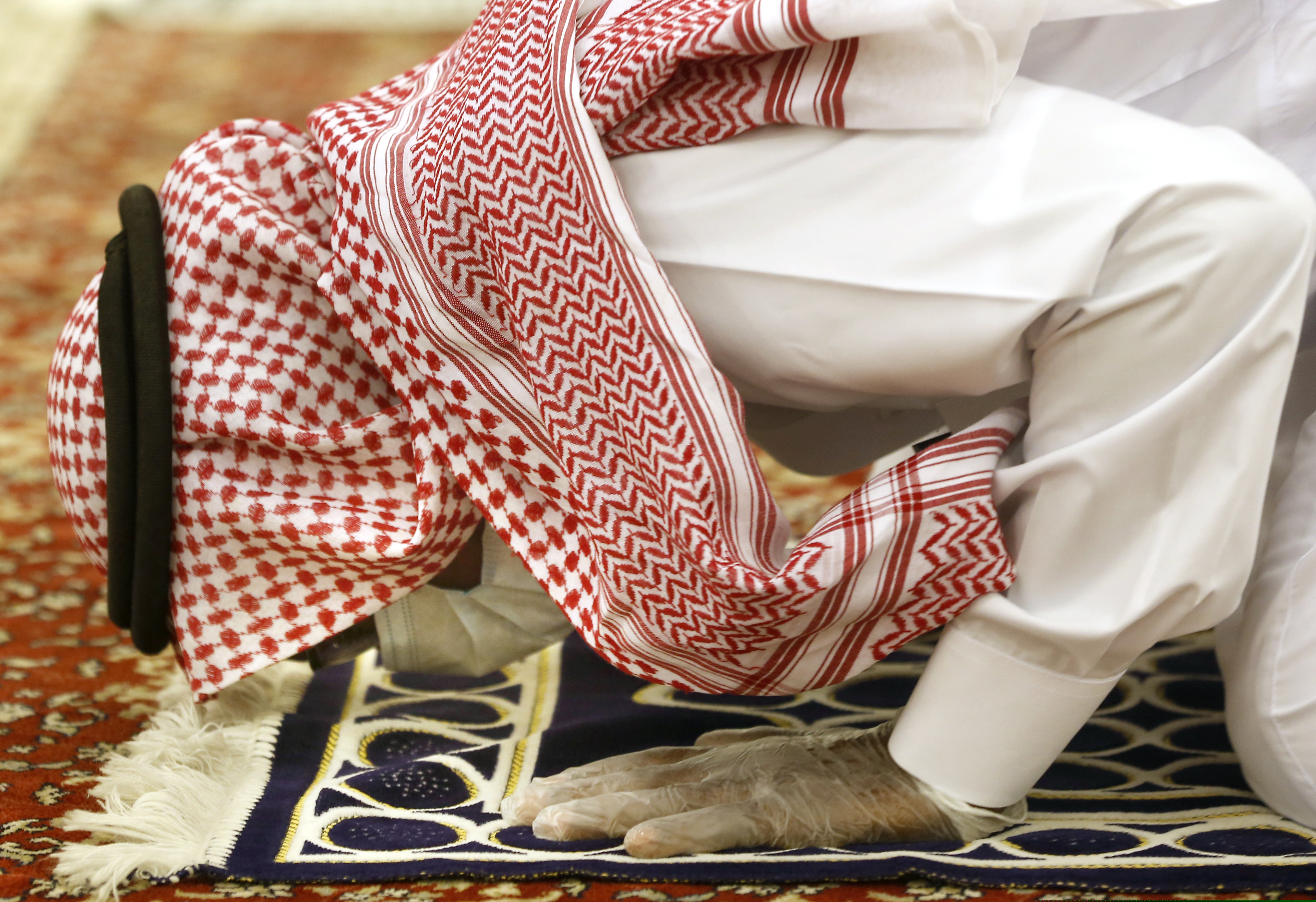 (AP Photo/Amr Nabil) A Saudi worshipper wearing a face mask and gloves to prevent the spread of COVID-19 as he prays dawn prayers at al-Mirabi Mosque in Jiddah, Saudi Arabia, Sunday, May 31, 2020.