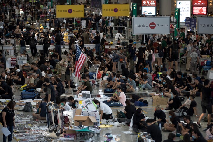 (Vincent Thian | AP Photo) Protesters stage a sit-in rally at the arrival hall of the Hong Kong International Airport in Hong Kong, Tuesday, Aug. 13, 2019. Protesters clogged the departure area at Hong Kong's reopened airport Tuesday, a day after they forced one of the world's busiest transport hubs to shut down entirely amid their calls for an independent inquiry into alleged police abuse.