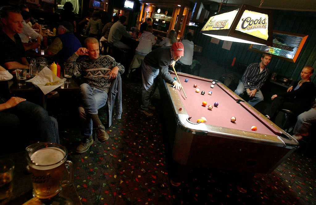 (Tribune file photo) Patrons of the Cotton Bottom Inn shoot pool, drink cold beer and eat their famous garlic burgers on Nov. 11, 2005. The iconic tavern is being purchased by the owners of Salt Lake City’s Bar X and Beer Bar, who plan to keep the signature garlic cheeseburgers and remodel it.
