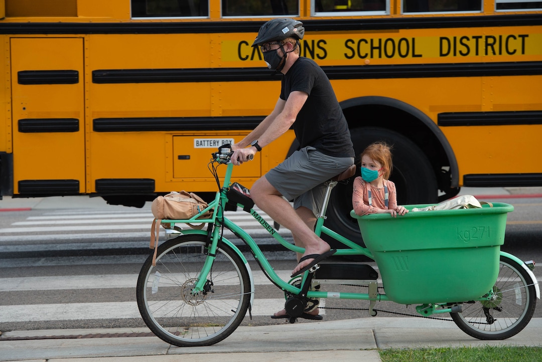 (Francisco Kjolseth  |  The Salt Lake Tribune) Chris Price rides his bike to school with daughter Eisley, 4, in the basket as they drop off her sister at Canyon View Elementary in Cottonwood Heights for the first day classes for the Canyons School District on Monday, August 24, 2020.