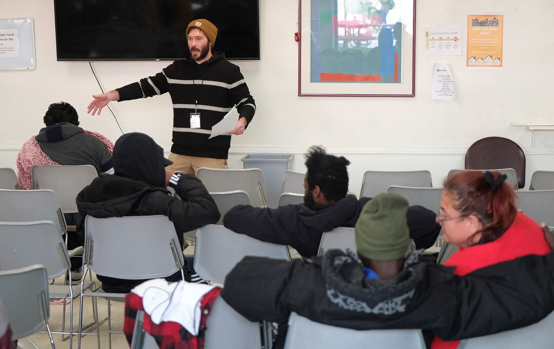 (Francisco Kjolseth  |  The Salt Lake Tribune) Joe Pace, Employment and Life Skills Coordinator leads a town hall meeting in the day room of the Weigand Center on Wednesday, Dec. 18, 2019, where Catholic Community Services hosts the weekly event to get more input from its homeless clients. In the back of the room there is a survey kiosk that asks clients about service, cleanliness and what people would like to see to better serve them.