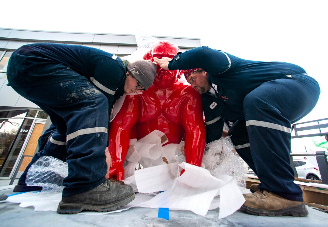 (Rick Egan | The Salt Lake Tribune)  Workers place a new art installation featuring a life-size sumo wrestler, in front of the Mountain West Commercial Real Estate building, previously the KALL Radio 910 broadcast station, on South Temple, in Salt Lake City, on Monday, March 29, 2021