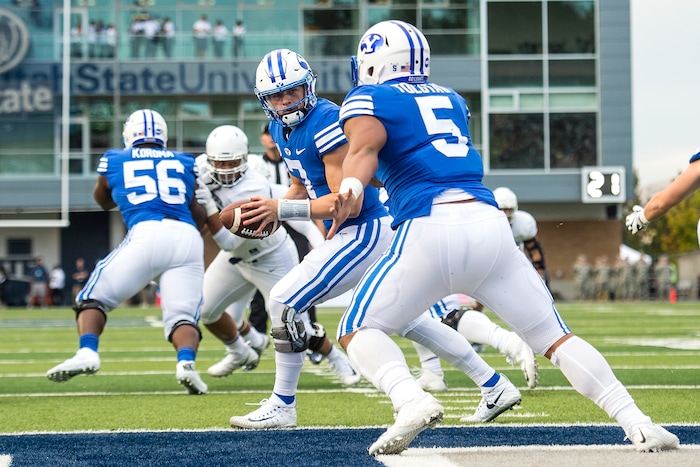 (Chris Detrick  |  The Salt Lake Tribune)  Brigham Young Cougars quarterback Beau Hoge (7) hands off to Brigham Young Cougars running back Ula Tolutau (5) during the game at Merlin Olsen Field at Maverik Stadium Friday, September 29, 2017.