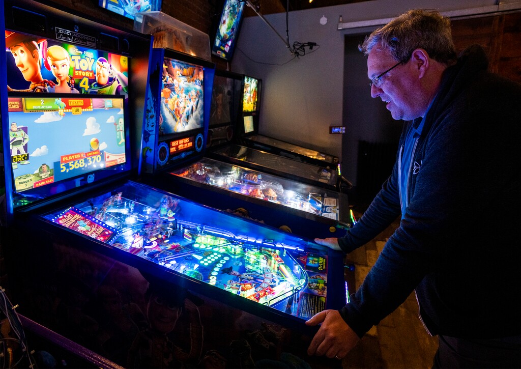 (Rick Egan | The Salt Lake Tribune) A customer plays the "Toy Story 4" pinball game at Lit Arcade Bar, in Ogden, on Thursday, Dec. 15, 2022. The bar received its liquor license on Nov. 17, 2022, after months of waiting, and opened just days after securing the license.