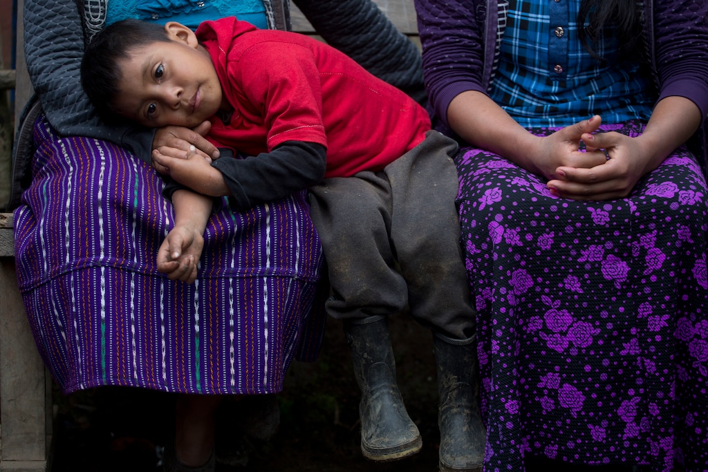 Six-year-old Mateo, the brother of Felipe Gomez Alonzo an 8-year-old Guatemalan boy who died in U.S. custody, rests his head on his mother's lap in their home in Yalambojoch, Guatemala, Saturday, Dec. 29, 2018. It was extreme poverty and lack of opportunity that drove Felipe’s father, Agustin Gomez, and mother Catarina Alonzo to decide that he and the boy would set off for the United States. (AP Photo/Moises Castillo)