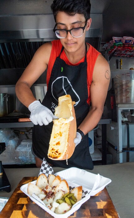(Rick Egan  |  Tribune file photo)   Zara Ahmed coats the "The Wasatch" bread and vegetables with melted raclette cheese in the Raclette Machine food truck in June 2019.