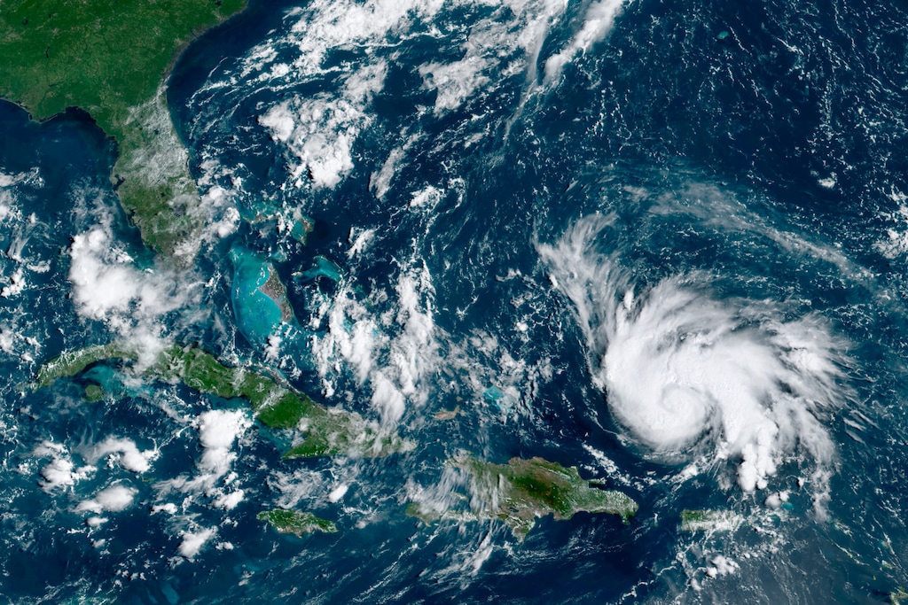 (NOAA via AP) This GOES-16 satellite image taken Thursday, Aug. 29, 2019, at 14:20 UTC shows Hurricane Dorian, right, moving over open waters of the Atlantic Ocean. The U.S. National Hurricane Center said Dorian was expected to grow into a potentially devastating Category 3 hurricane before hitting the U.S. mainland late Sunday or early Monday somewhere between the Florida Keys and southern Georgia.