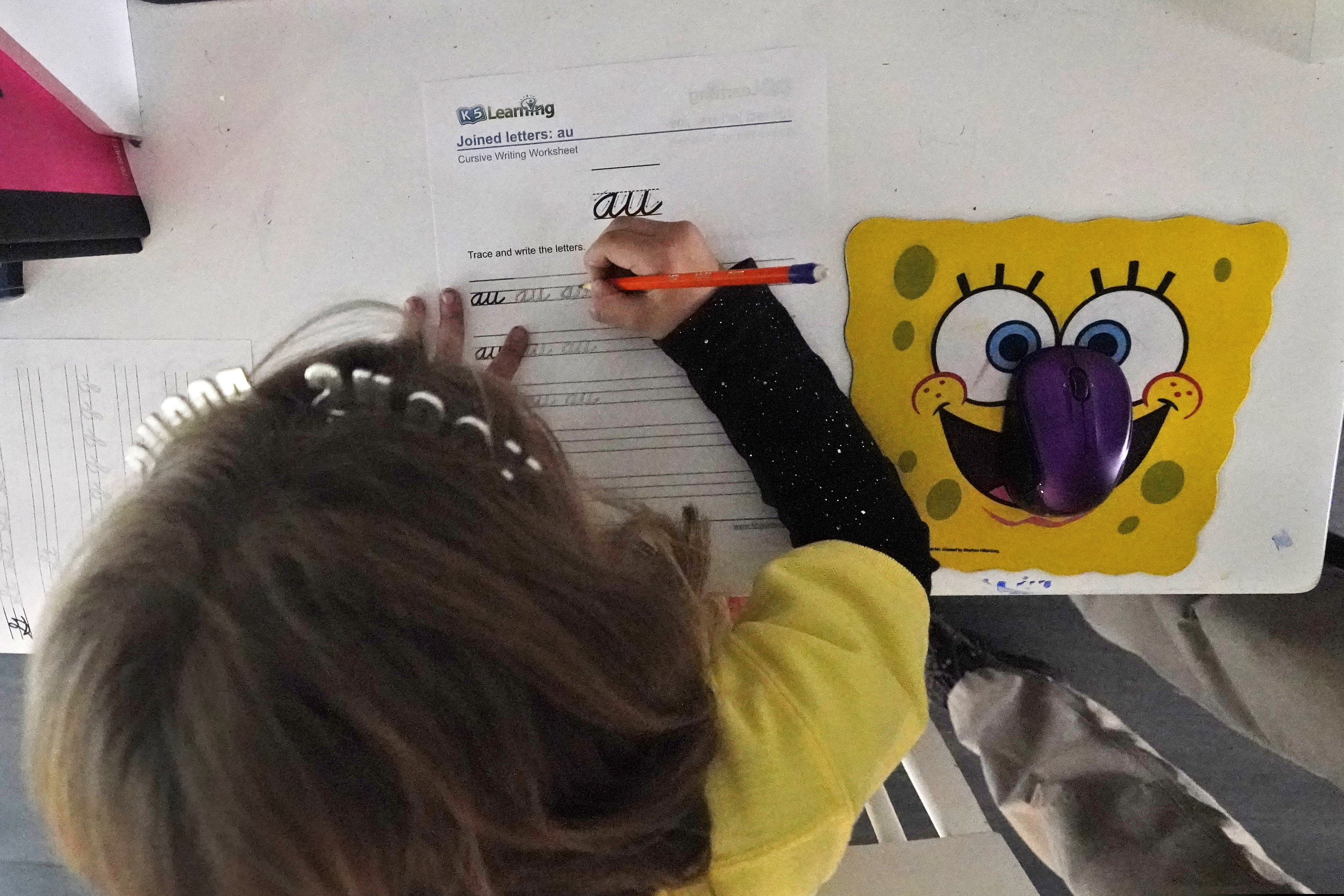 (Wilfredo Lee | AP file photo) A student works on a cursive writing exercise after having finished remote learning for the day, Thursday, Oct. 1, 2020, at her home in North Miami Beach, Fla.