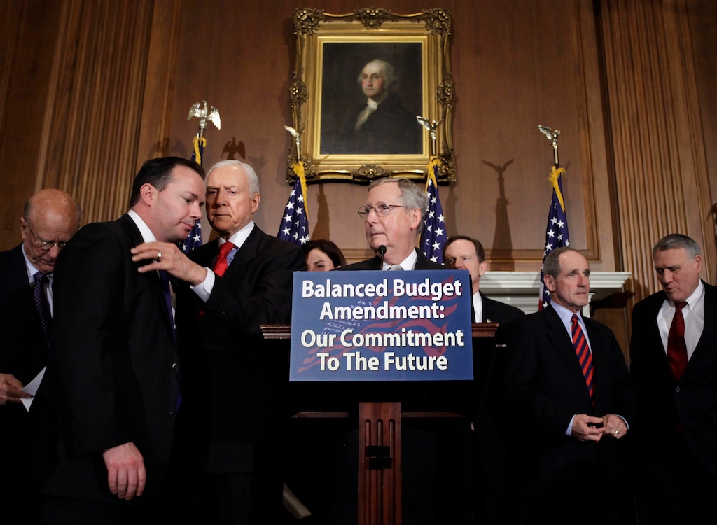 Senate Republican leader Mitch McConnell of Kentucky gathers other Republican senators to call for an amendment to the Constitution requiring a balanced federal budget, at the Capitol in Washington, Thursday, March 31, 2011. To the left are Sen. Orrin Hatch, R-Utah, conferring with Sen. Mike Lee, R-Utah. (AP Photo/J. Scott Applewhite)