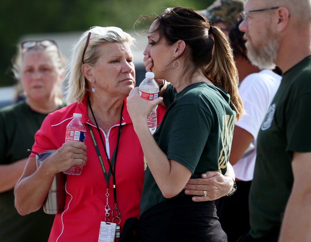 Santa Fe High School staff react as they gather in the parking lot of a gas station following a shooting at the school in Santa Fe, Texas, on Friday, May 18, 2018.   (Jennifer Reynolds/The Galveston County Daily News via AP)