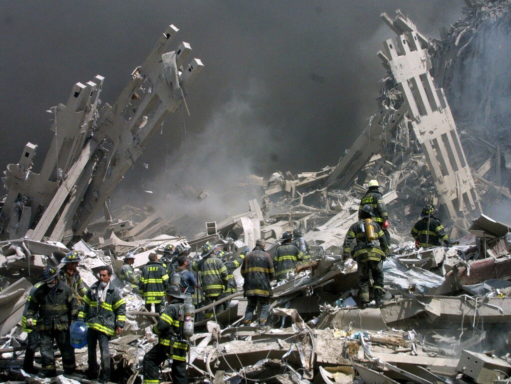 FILE - In this Sept. 11, 2001 file photo, firefighters make their way through the rubble after two airliners crashed into the World Trade Center in New York bringing down the landmark buildings. The White House lashed out at Congress on Thursday, Sept. 29, 2016, a day after Republicans and Democrats overwhelmingly overrode President Barack Obama’s veto of a bill to allow families of the 9/11 victims to sue Saudi Arabia. The White House turned to mockery as top GOP leaders expressed buyer's remorse and vowed to fix the bill. (AP Photo/Shawn Baldwin/File)
