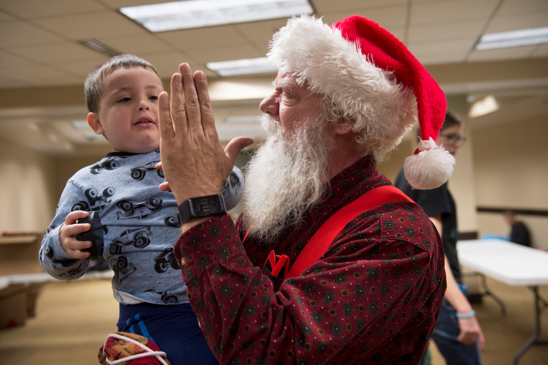 (Scott Sommerdorf   |  The Salt Lake Tribune)   Fred Lane offers a high five to a young one holding a hockey puck as Lady Gaga's Born This Way Foundation hosted an event at the Maverick Center to assemble care packages and write ÒKindness LettersÓ expressing support, hope, and love for LGBT+ youth experiencing homelessness in the area, Thursday, December 14, 2017.  