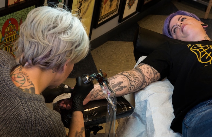 (Rick Egan | The Salt Lake Tribune) Molly Regan-Carlton gets a tattoo from Ashley Love, at the Yellow Rose Tattoo during a flash tattoo event where all proceeds go to the Rape Recovery Center of Utah. It's part of a national event where tattoo shops raise money for sexual assault victims. Sunday, June 10, 2018.