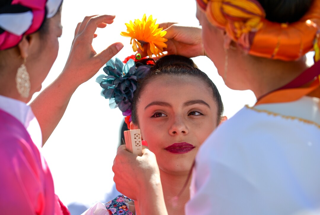 (Leah Hogsten  |  The Salt Lake Tribune) Mayleen Murillo, 14, gets her hair styled by Yesenia Rivas, left, and Mabel Sellers at the Cinco de Mayo Celebration, Saturday, May 5, 2018 at Centennial Park in West Valley City.