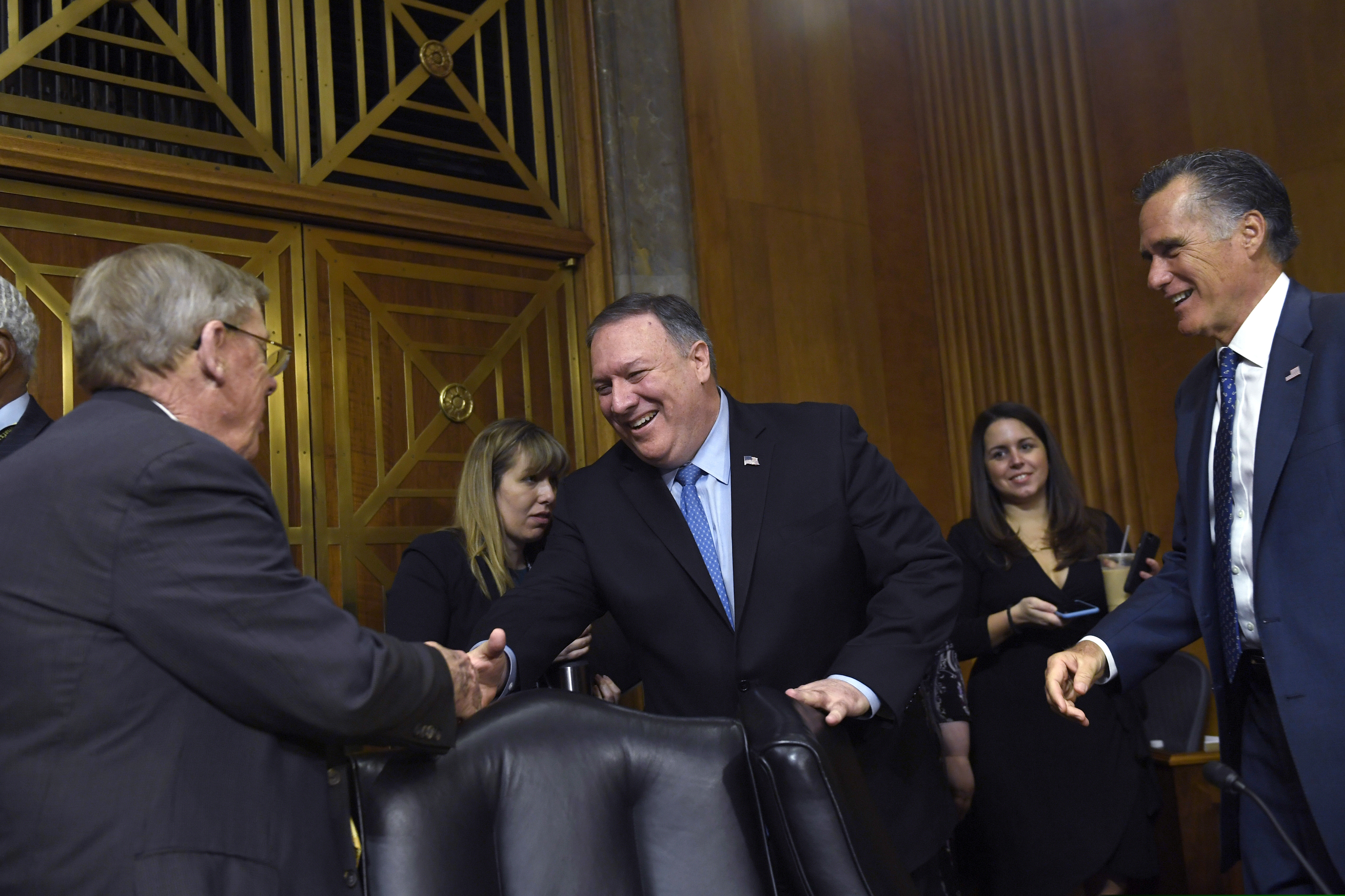 Secretary of State Mike Pompeo, center, shakes hands with Sen. Johnny Isakson, R-Ga., left, as Sen. Mitt Romney, R-Utah, right, watches, as he arrives to testify before the Senate Foreign Relations Committee on Capitol Hill in Washington, Wednesday, April 10, 2019, during a hearing to review the FY 2020 State Department budget request. (AP Photo/Susan Walsh)