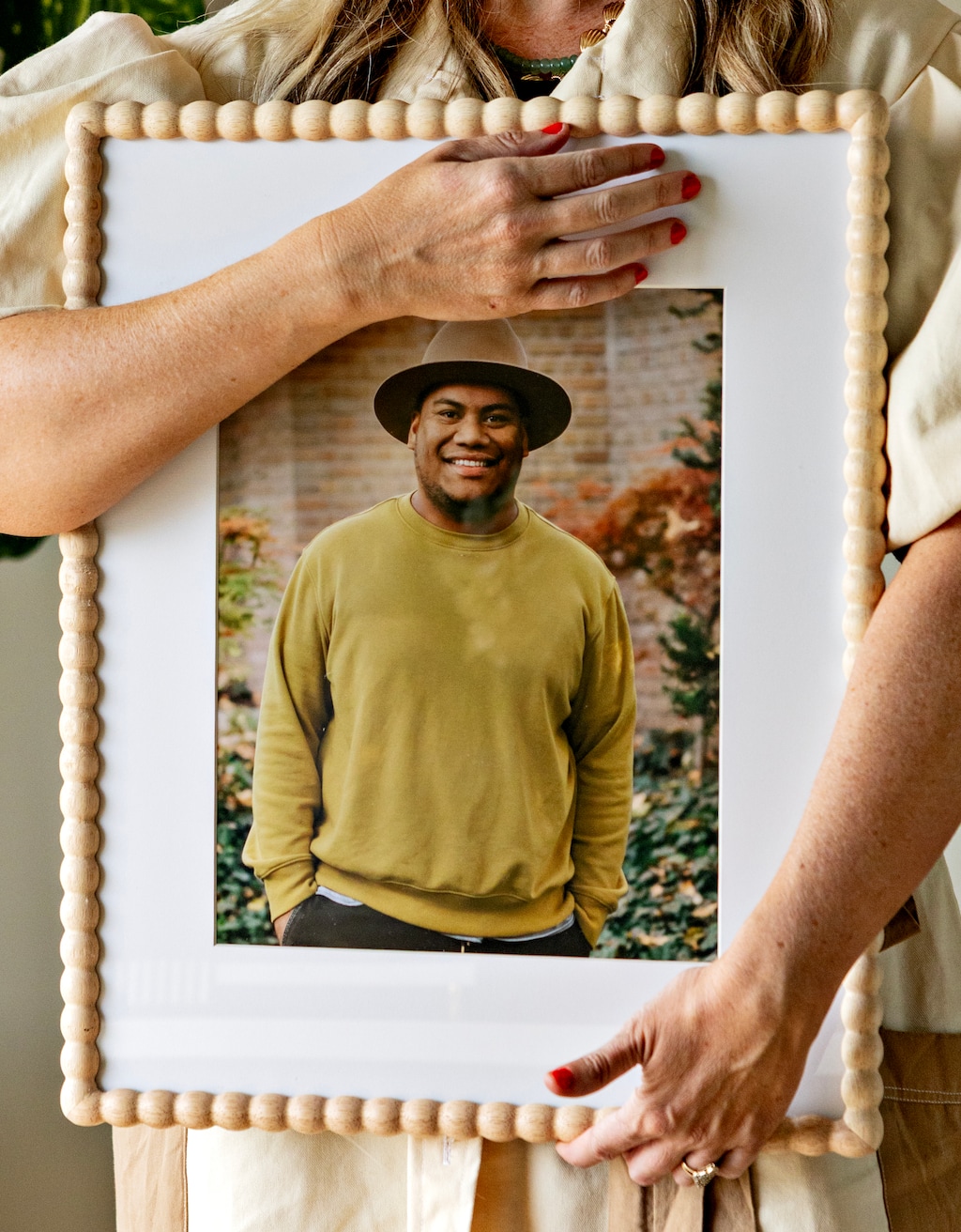 (Kim Raff/The New York Times) Laura Ah Loo holds a portrait of her husband, Afa Ah Loo, at her home in Clearfield on May 3, 2026. 