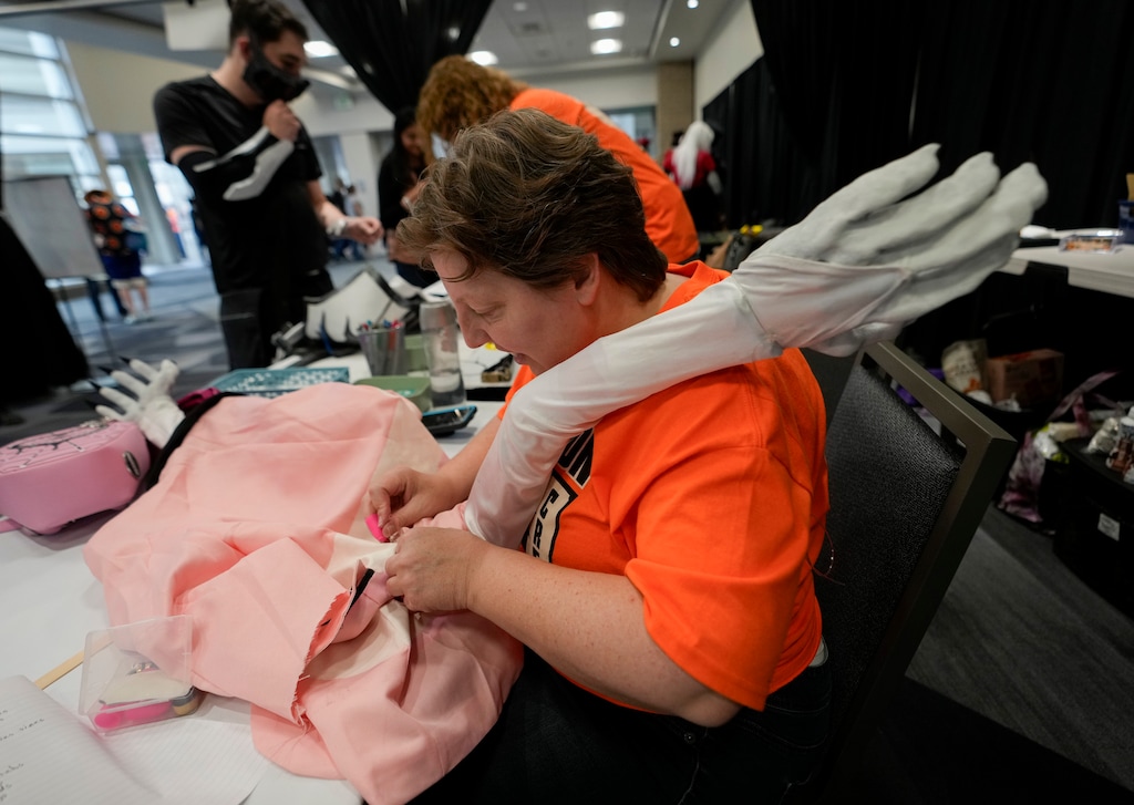 (Bethany Baker | Salt Lake Tribune) Trisha Holmes works as a volunteer at the Cosplay Repair Lounge at the FanX Salt Lake Pop Culture & Comic Convention, sewing an arm back onto a costume at Salt Palace Convention Center in Salt Lake City on Friday, Sept. 22, 2023.