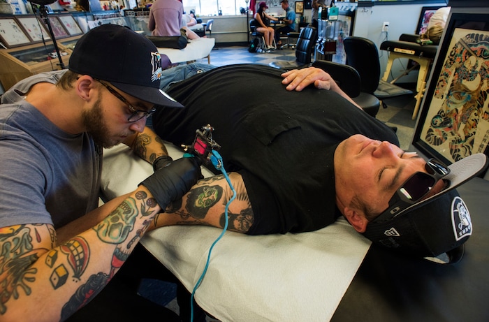 (Rick Egan | The Salt Lake Tribune) Shane VanMaack, gets a tattoo from Kyle Crossly, at the Yellow Rose Tattoo, during a flash tattoo event where all proceeds go to the Rape Recovery Center of Utah. It's part of a national event where tattoo shops raise money for sexual assault victims. Sunday, June 10, 2018.