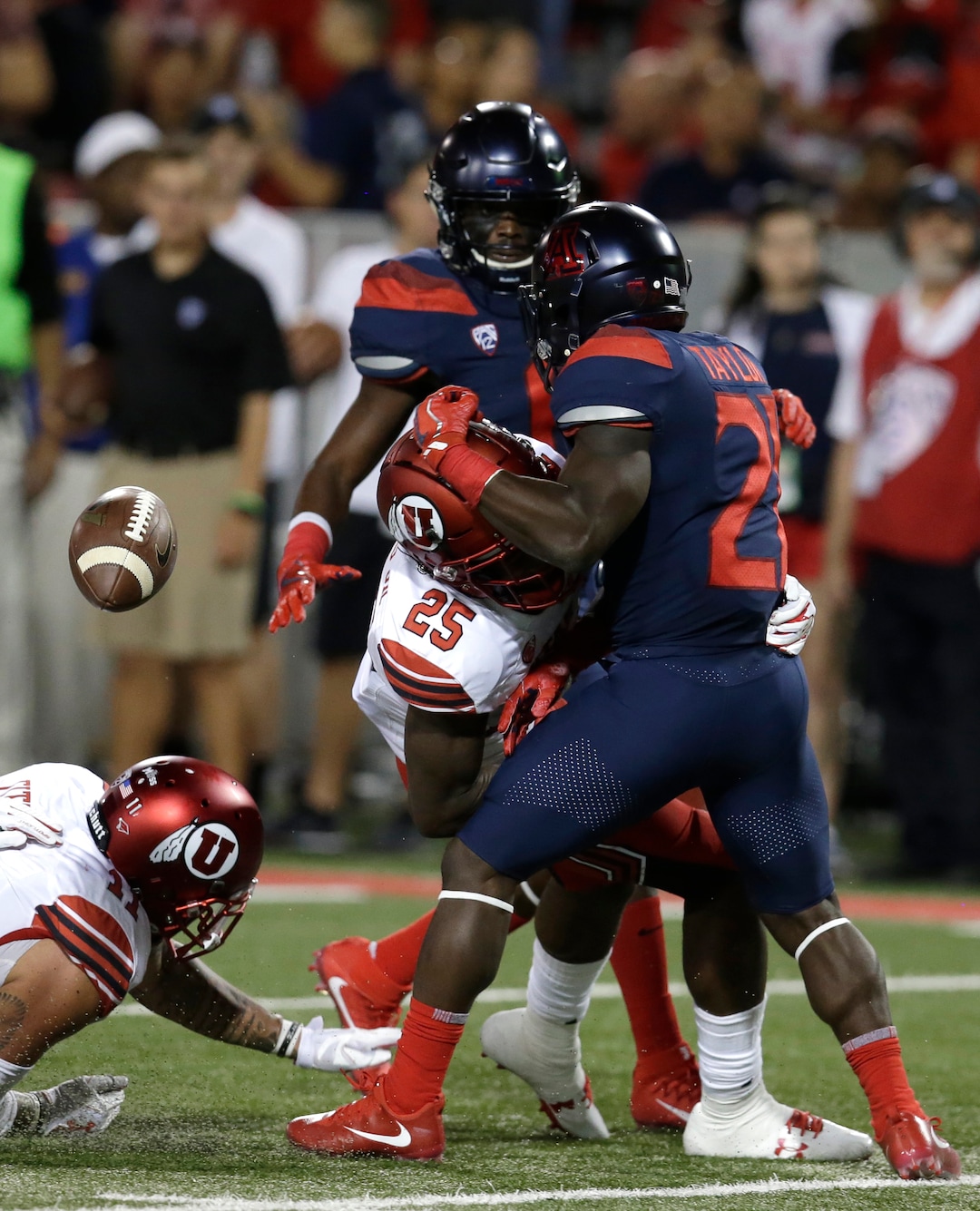 Arizona running back J.J. Taylor (21) fumbles the ball after getting hit by Utah defensive back Casey Hughes (25) during the first half during an NCAA college football game, Friday, Sept. 22, 2017, in Tucson, Ariz. Utah recovered the fumble. (AP Photo/Rick Scuteri)