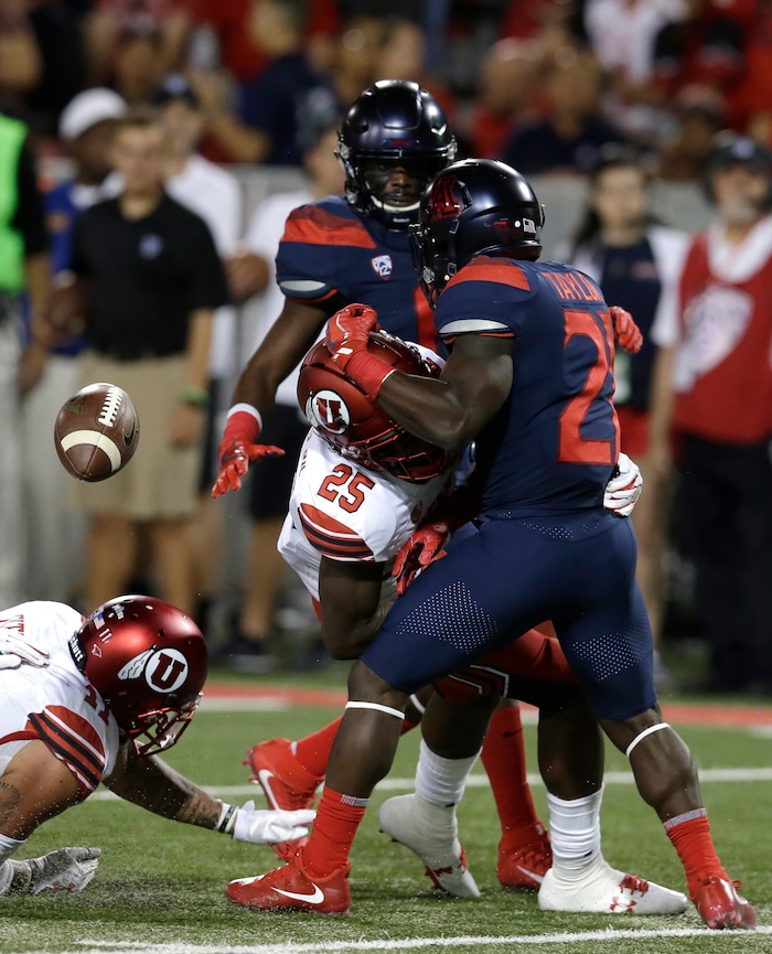 Arizona running back J.J. Taylor (21) fumbles the ball after getting hit by Utah defensive back Casey Hughes (25) during the first half during an NCAA college football game, Friday, Sept. 22, 2017, in Tucson, Ariz. Utah recovered the fumble. (AP Photo/Rick Scuteri)