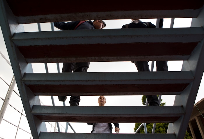 In this Aug. 25, 2017 photo, a female nursing student climbs the stairs behind fellow male students at a nursing school in Nezahualcoyotl, Mexico state. The State of Mexico officially ranks second to the nation's capital with 346 killings classified as femicides since 2011, according to government statistics. (AP Photo/Rebecca Blackwell)