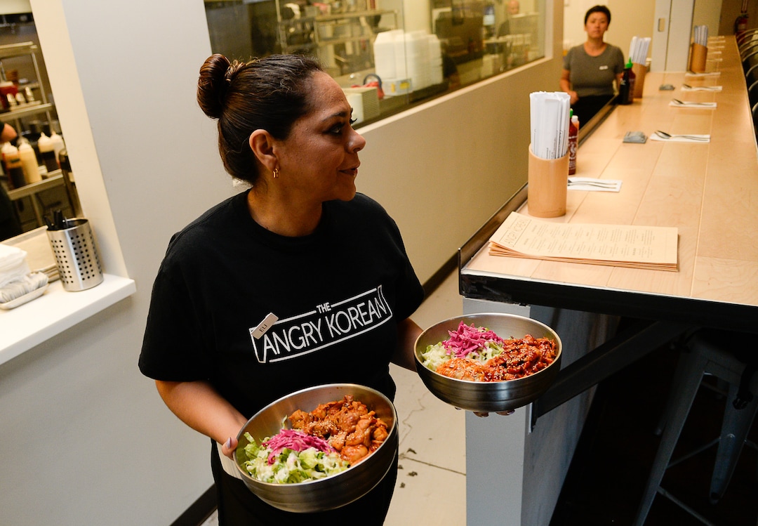 (Francisco Kjolseth  |  The Salt Lake Tribune)  Eli Peniche delivers an assortment of rice bowls at the Angry Korean fusion restaurant prepares meals during the lunch hour on Wed. Sept. 4, 2019. Originally started with a food truck, they now have a sit-down restaurant in South Jordan.