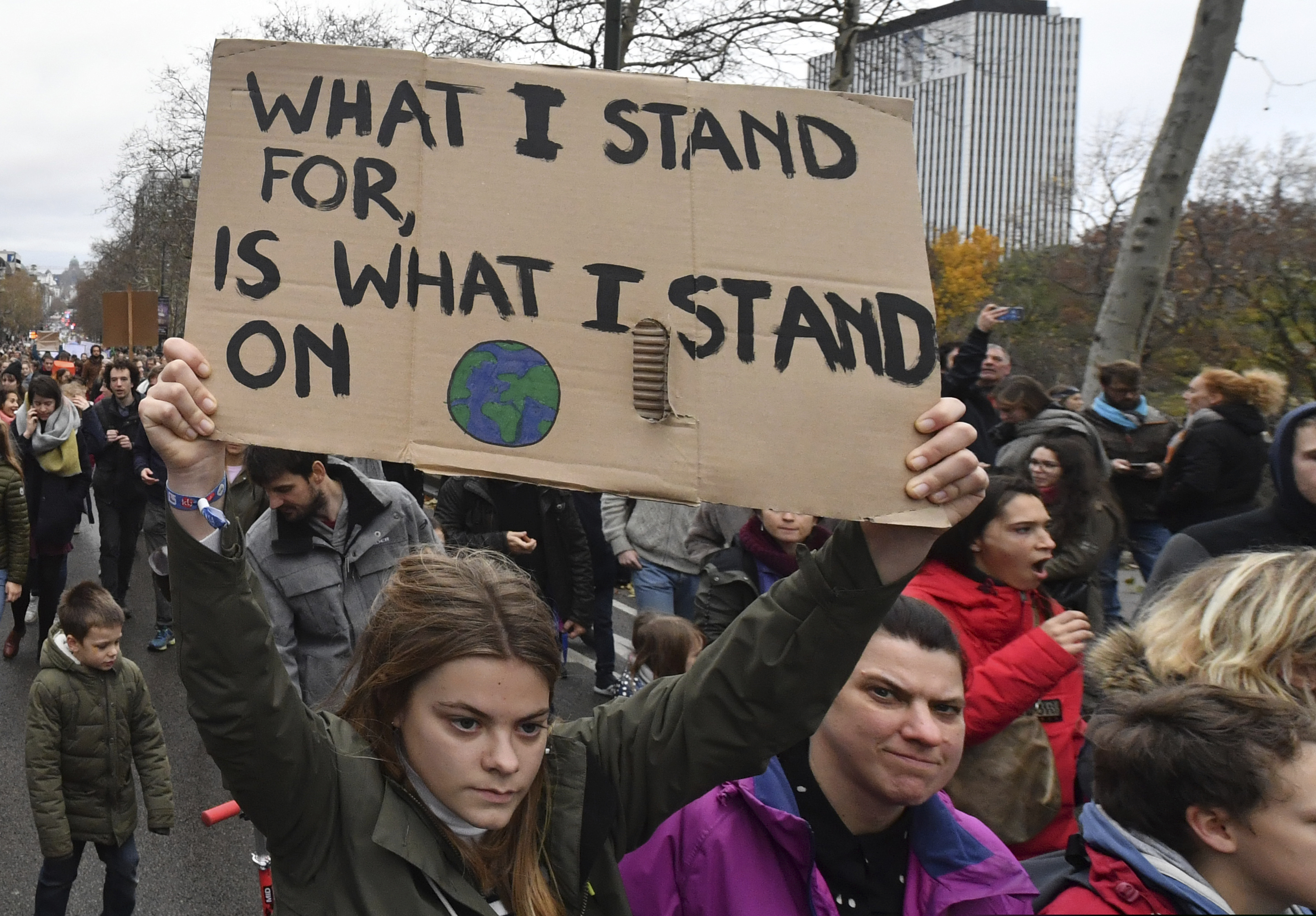 A demonstrator holds a placard during a Claim the Climate march in Brussels, Sunday, Dec. 2, 2018. The climate change conference, COP24, will take place in Poland Dec. 2-14. (AP Photo/Geert Vanden Wijngaert)
