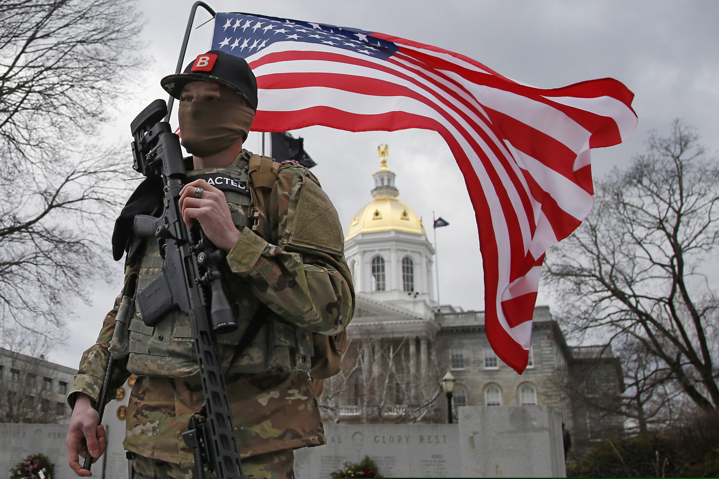 (Winslow Townson | The Associated Press) An armed protester stands in front of the statehouse on Sunday, Jan. 17, 2021, in Concord, N.H.
