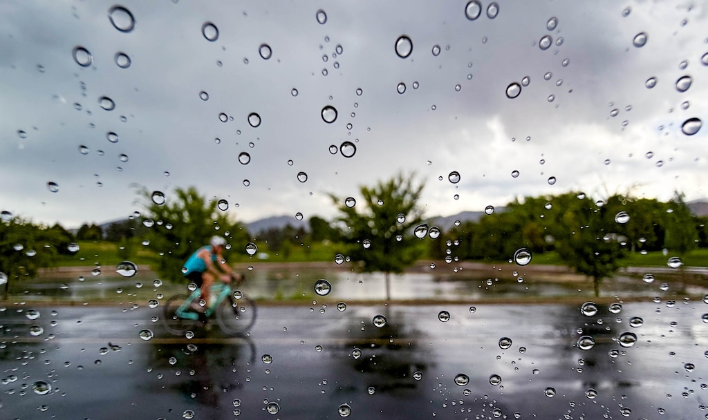 (Francisco Kjolseth | The Salt Lake Tribune) A cyclists rides in the rain in Sugar House Park on Saturday, Aug. 22, 2026. 