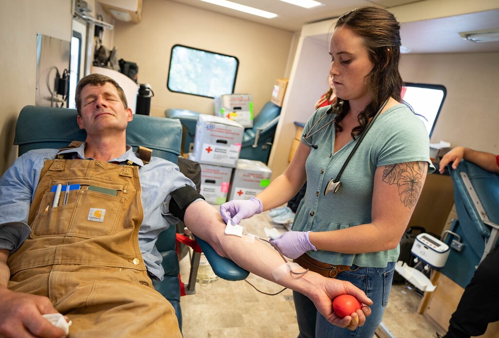 (Francisco Kjolseth | The Salt Lake Tribune) Karl Ebeling who goes by “farmer Karl,” makes one of his regular blood donations, something he has been doing for 35 years. Phlebotomist Erica Millet with the American Red Cross assists him inside a mobile unit parked at the Sandy Library on Tuesday, June 29, 2021.