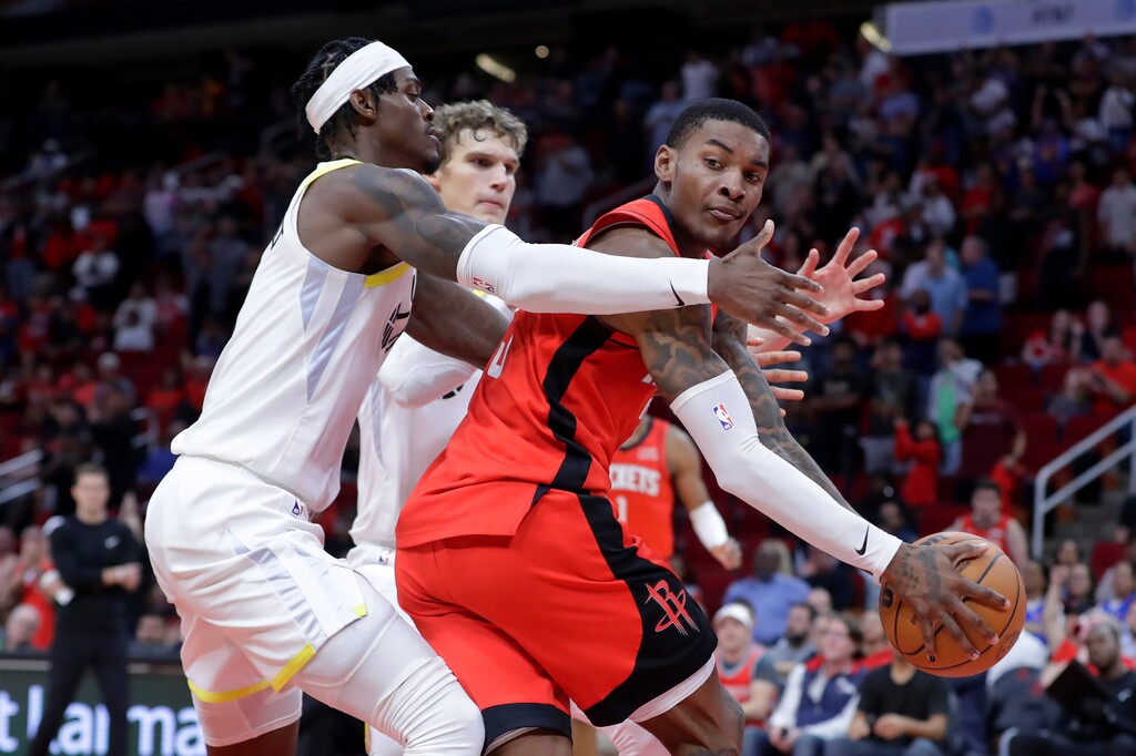 (Michael Wyke | The Associated Press) Houston Rockets guard Kevin Porter Jr., right, looks to pass the ball as Utah Jazz forwards Jarred Vanderbilt, left, and Lauri Markkanen, center, box him up during the second half of an NBA basketball game Monday, Oct. 24, 2022, in Houston.