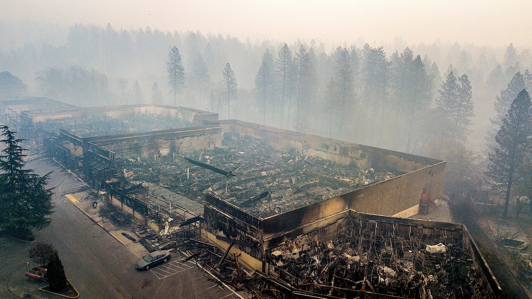 Smoke hangs over the scorched remains of Old Town Plaza following the wildfire in Paradise, Calif., on Thursday, Nov. 15, 2018. The shopping center housed a Safeway and other businesses. (AP Photo/Noah Berger)