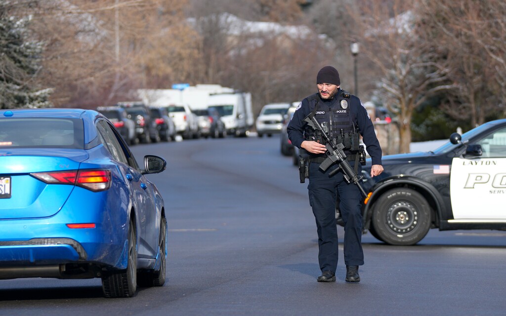 (Bethany Baker | The Salt Lake Tribune) A police officer approaches a vehicle at a checkpoint along Oak Lane after reports of shots fired in Layton on Thursday.