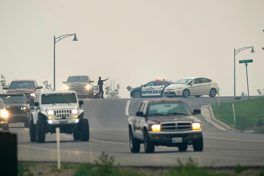 (George Frey  | Special to The Tribune) An officer directs traffic as people are evacuated from their homes in south Saratoga Springs due to a wildfire on June 28, 2020.