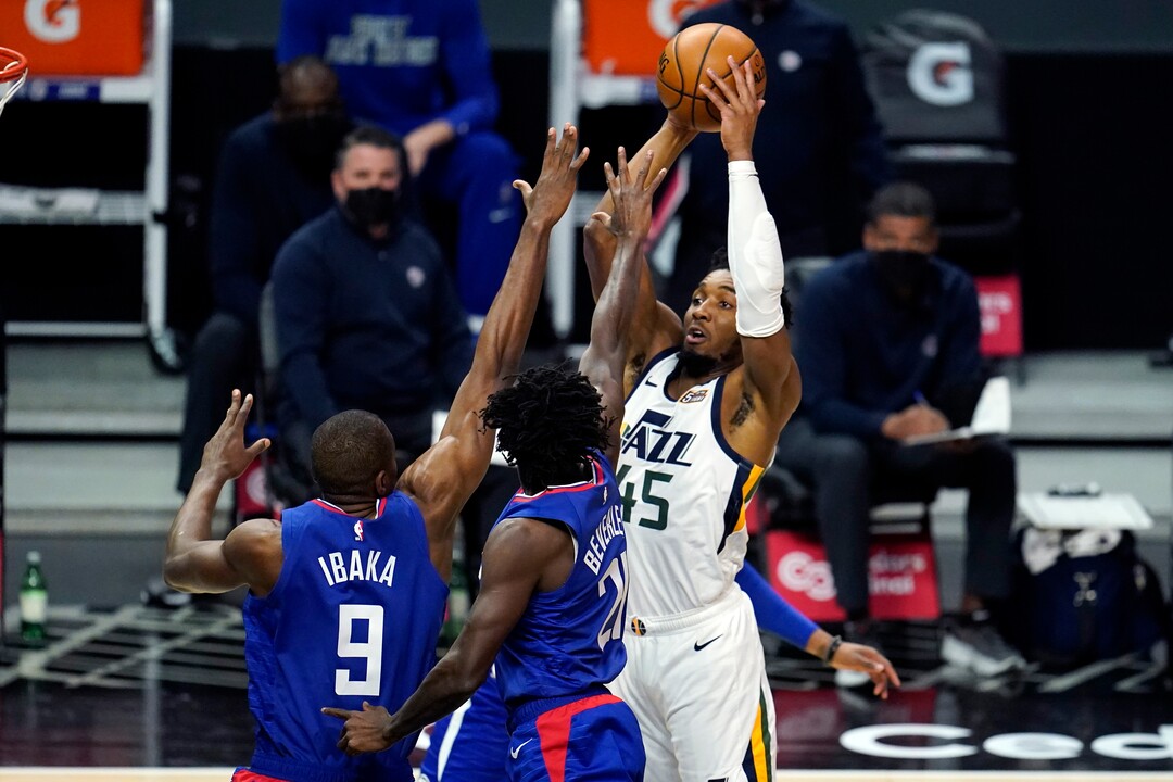 Utah Jazz guard Donovan Mitchell, right, shoots over Los Angeles Clippers' Patrick Beverley, center, and Serge Ibaka (9) during the first half of an NBA basketball game Wednesday, Feb. 17, 2021, in Los Angeles. (AP Photo/Marcio Jose Sanchez)