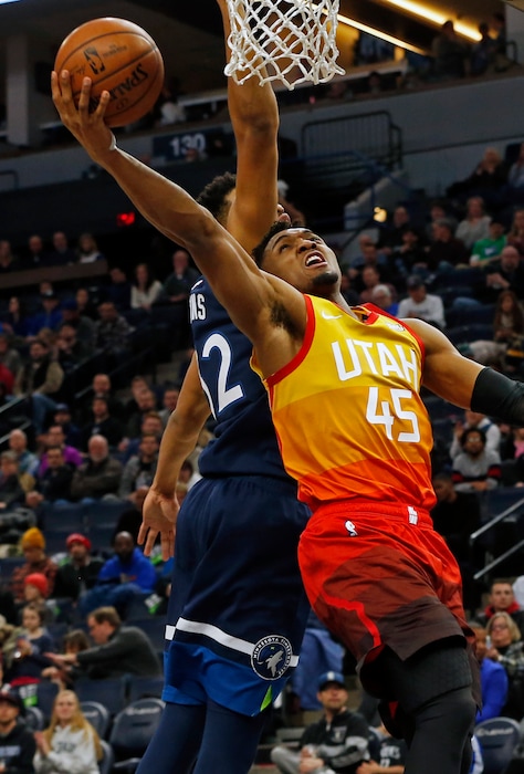 Utah Jazz's Donovan Mitchell, right, lays up a shot as Minnesota Timberwolves' Karl-Anthony Towns defends in the first half of an NBA basketball game Sunday, Jan. 27, 2019, in Minneapolis. (AP Photo/Jim Mone)
