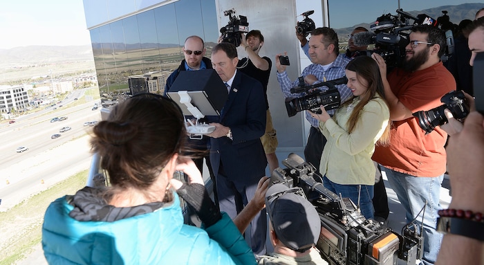 (Al Hartmann | The Salt Lake Tribune)
News photographers surround Gov. Gary R. Herbert, center, as he uses remote control to pilot a drone in Lehi Wednesday April 25 to get a view of the Utah Department of Transportation’s (UDOT) I-15 Tech Corridor project in Lehi for a pre-construction site tour. The project will widen I-15 with two new lanes in each direction from Lehi Main Street to S.R. 92. It will also alleviate east-west congestion in this busy area by building a bridge at Triumph Boulevard, adding a one-way frontage road system from 2100 North to S.R. 92 and reconstructing those two interchanges. In addition, the project will construct 17 bridges and include several bike and pedestrian improvements.