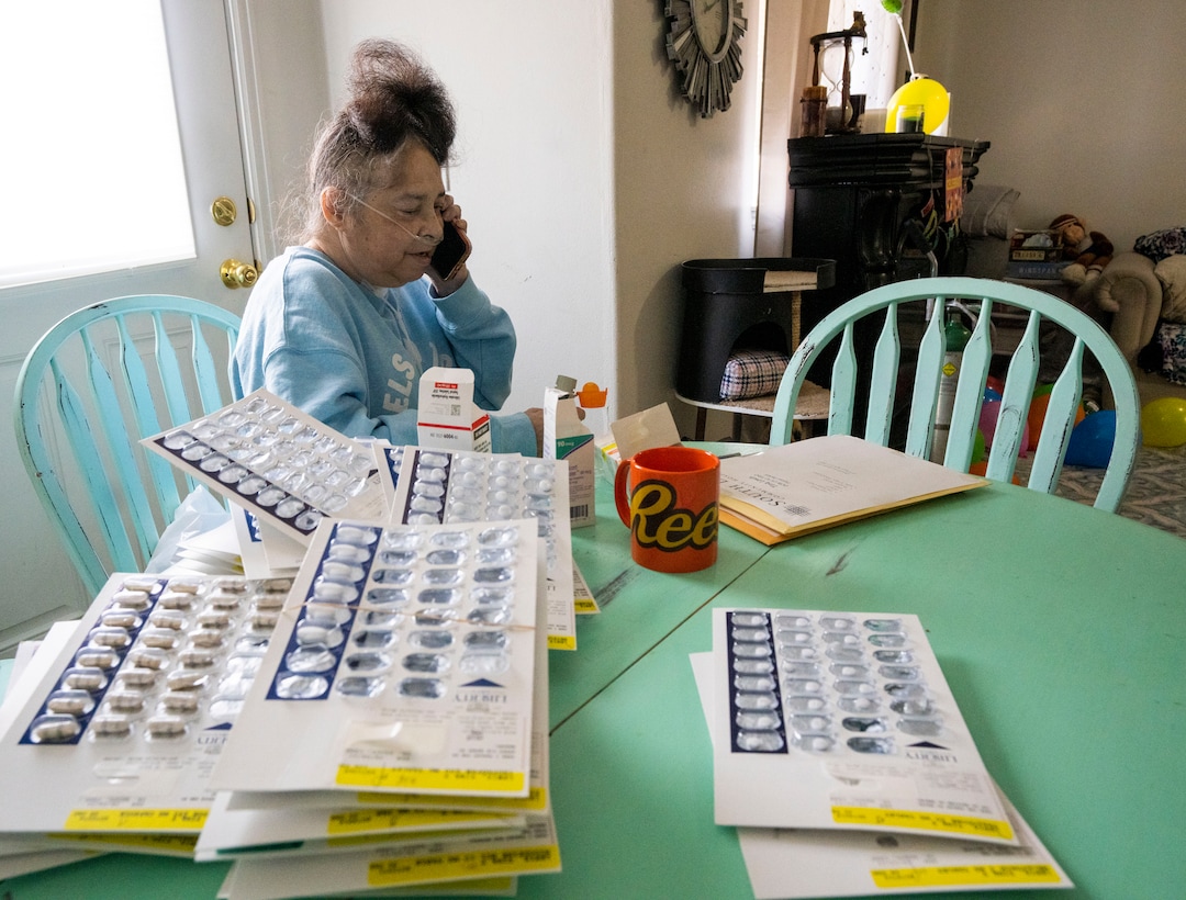 (Rick Egan | The Salt Lake Tribune) Tina Lewis answers a phone call from her dad as she sifts through the dozens of medications on her first full day home at Idaho Falls, Idaho, on Thursday, Sept. 23, 2021. Lewis spent most of the past 6 months in hospitals sick with COVID-19.