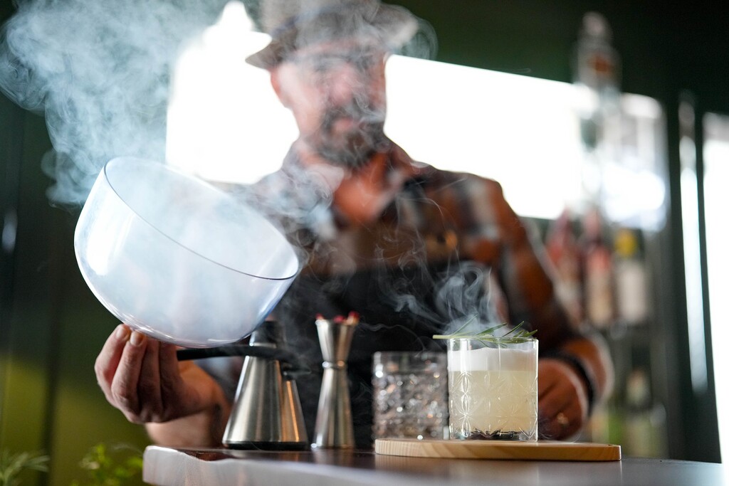 (Francisco Kjolseth | The Salt Lake Tribune) Bar co-owner Matthew LaPlante smokes a drink at 1833 Craft, a zero-alcohol craft cocktail bar, on Wednesday, Oct. 22, 2025.

