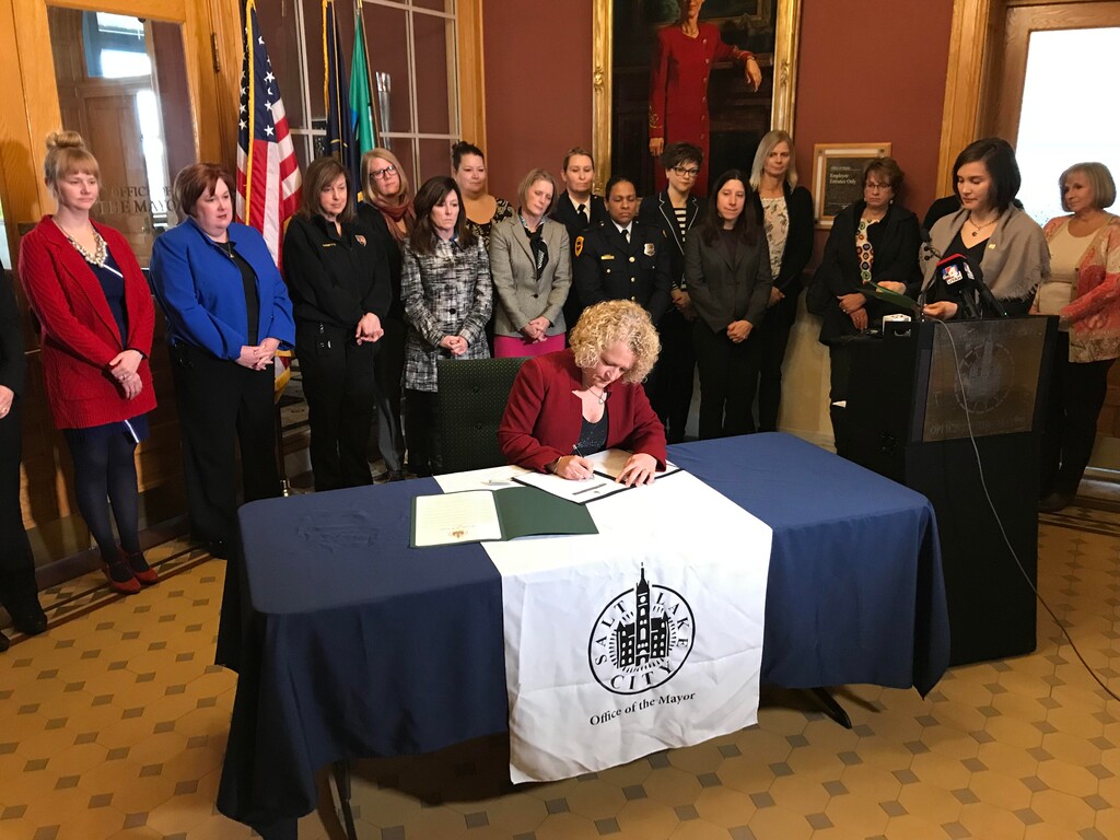 Salt Lake City Mayor Jackie Biskupski signs into effect a new city policy to ensure gender pay equity in a ceremony March 1, the start of Women's History Month. She is joined by City Council Chairwoman Erin Mendenhall and surrounded by women who serve as city department and division heads.
