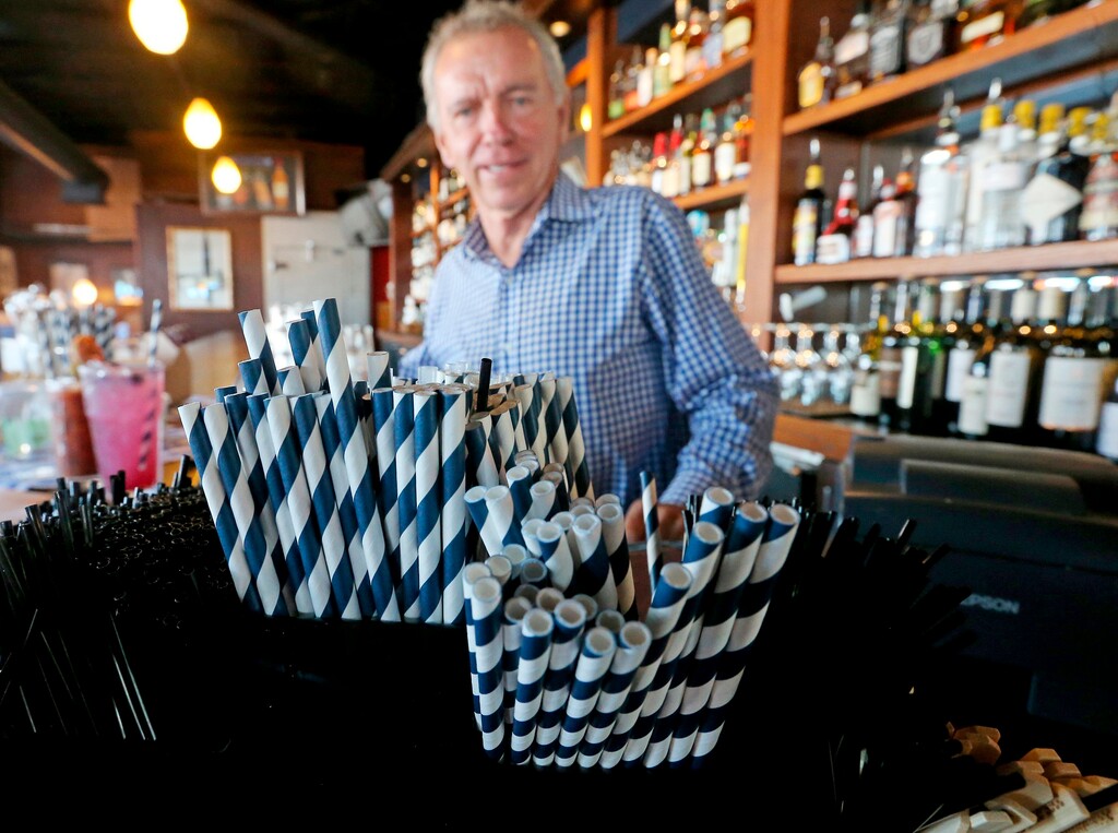 In this June 19, 2018 photo, paper straws sit at Duke Moscrip, owner of Duke's Restaurants, bar at his restaurant in Seattle. Businesses that sell food or drinks won’t be allowed to offer the plastic items under a rule that went into effect Sunday, July 1. (Greg Gilbert/The Seattle Times via AP)