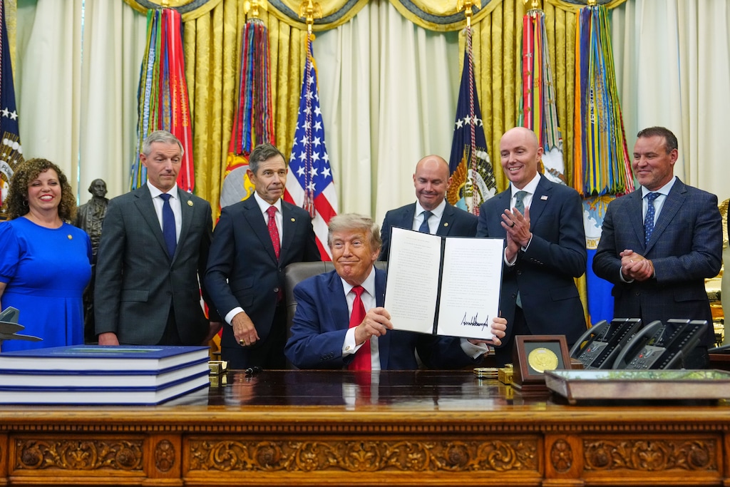 (Julia Demaree Nikhinson | AP) President Donald Trump holds a signed executive order in the Oval Office of the White House, Monday, July 13, 2026, in Washington. Behind Trump, from left: U.S. Reps. Celeste Maloy and Mike Kennedy; U.S. Sens. John Curtis and Mike Lee; Gov. Spencer Cox; and House Speaker Mike Schultz.