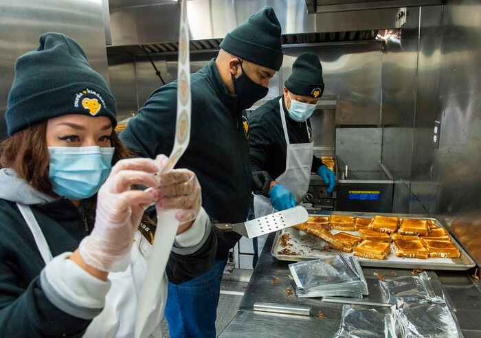 (Rick Egan | The Salt Lake Tribune)  Lissette Torres and Sid Burgos and Mike Youseff make grilled cheese sandwiches for 600 health care workers as part of the the Curds + Kindness program, which supports local dairy farmers, at the South Jordan Health Center in Daybreak on Tuesday, Dec. 1, 2020.