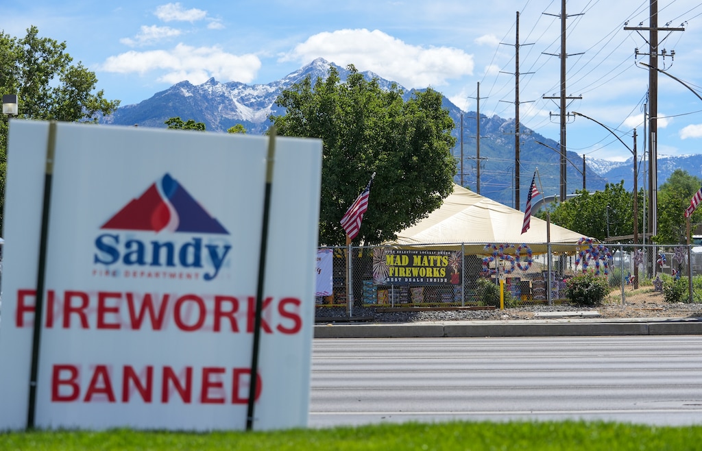 (Chris Samuels | The Salt Lake Tribune) A sign from Sandy Fire Department warning about a fireworks ban is seen across the street from a fireworks vendor. Law enforcement agencies have set up ways for residents to report illegal fireworks usage.